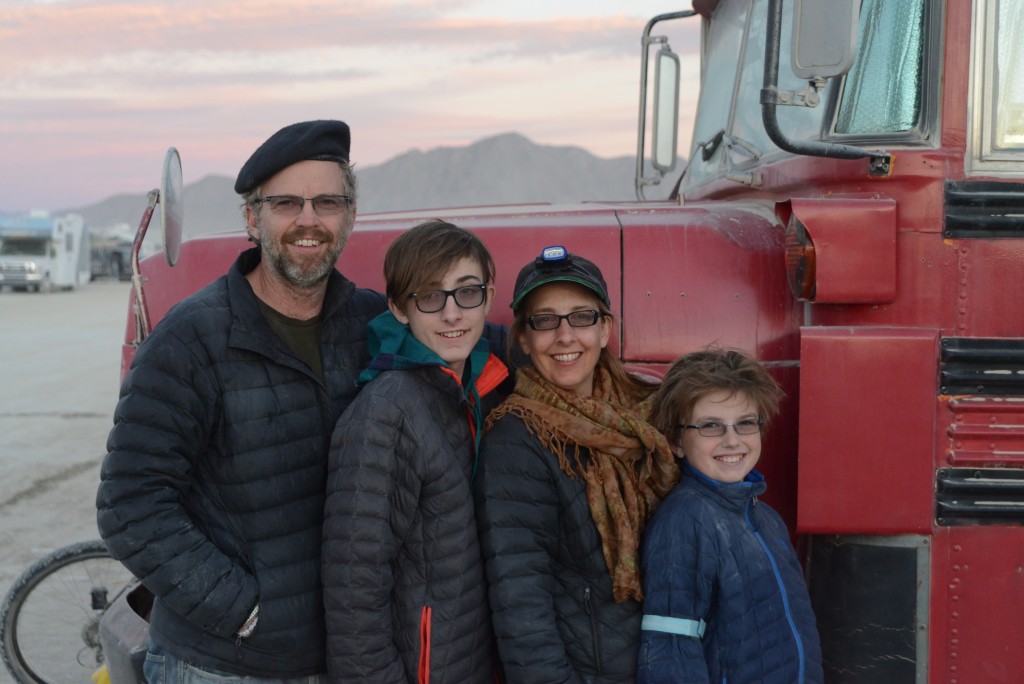 The four of us in front of our traveling red bus at Black Rock City, Burning Man